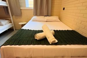 a room with a bed with a towel on it at 2 Suítes com Ar e Cozinha Completa in Andradina