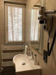 a white bathroom with a sink and a mirror at Appart-Hotel Gwendy in Bour