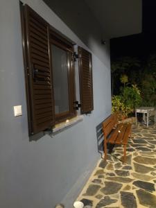 a bench sitting next to a building with windows at Mani GuestHouse in Kyparissos