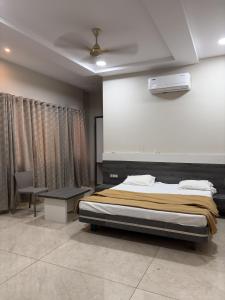 a bedroom with a bed and a table and a projector at Hotel VITHAI PALACE in Mehekar