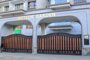 a man standing in front of a building with a wooden gate at Meteor gardens in Nairobi +2 photos