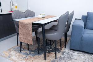 a dining room table with chairs and a blue couch at Meteor gardens in Nairobi