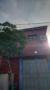 a garage with a tree in front of a building at Le perchoir bleu in Lomé