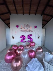 a bunch of balloons in a room with a sign at Green Valley a 5 min de Xielo Paracaidismo,la pista secreta y Paintball rural Leticia in Ricaurte +29 photos