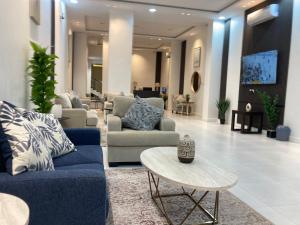 a living room with blue couches and a table at الكادي للشقق المخدومة in Ad Dawādimī