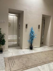 a blue christmas tree in the lobby of a building at الكادي للشقق المخدومة in Ad Dawādimī