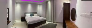 a hotel room with a bed and a purple light at الكادي للشقق المخدومة in Ad Dawādimī