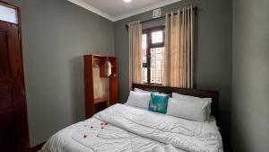 a bedroom with a bed with a window and a bedspread at Jubilant Experience Homes Arusha in Arusha