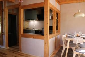 a kitchen with wooden walls and a table with chairs at Ferienwohnung Am Tharandter Wald 2 in Wilsdruff