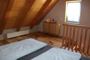 a bedroom with a bed and a window and wooden ceilings at Ferienwohnung Am Tharandter Wald 2 in Wilsdruff