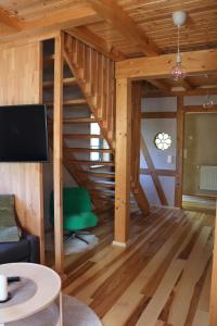 a living room with a wooden staircase with a green chair at Ferienwohnung Am Tharandter Wald 2 in Wilsdruff