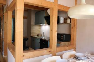 a kitchen with wooden walls and a table with chairs at Ferienwohnung Am Tharandter Wald 2 in Wilsdruff +6 photos