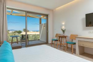 a bedroom with a king bed and a living room at Tsamis Zante Suites in Kypseli