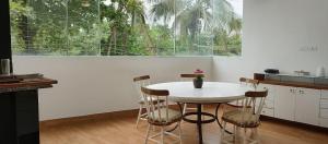 a kitchen with a table and chairs and a window at Refúgio com Churrasqueira na Praia in Bertioga
