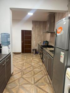 a kitchen with a refrigerator and a tile floor at Richard House in Villa Dolores