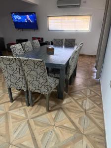 a dining room table with chairs and a television at Richard House in Villa Dolores