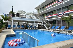a swimming pool with a beach ball in front of a building at Grecian Garden Motel in North Wildwood