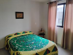 a bedroom with a bed with a quilt on it at Casa Lulu junto a Queretaro in Apaseo el Grande +29 photos