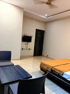 a bedroom with a bed and a table and chairs at Hotel VITHAI PALACE in Mehekar
