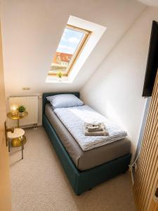 a small bedroom with a bed with a skylight at Hotel & Restaurant Hasa in Gernrode - Harz +4 photos