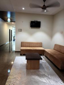 a living room with a couch and a coffee table at Hotel VITHAI PALACE in Mehekar