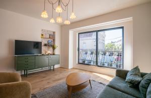 a living room with a couch and a large window at Les Camuches de la banque - Appartements privatifs de 35 à 110 m2 avec patios - Centre ville in Tournai