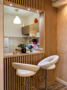 a kitchen with two white stools in front of a counter at New Moment in Žarkovo