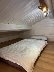 a white bed in a room with a ceiling at Seesen Private Lodge in Seesen