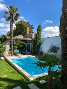 a pool in front of a house with a palm tree at Le loft chambre et salon climatisés in Croix-Chapeau