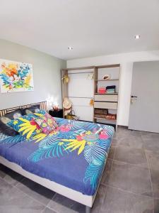 a bedroom with a bed with a blue comforter at BLUE DREAM SPA in Les Trois-Îlets