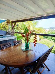 a wooden table with a vase of flowers on it at BLUE DREAM SPA in Les Trois-Îlets
