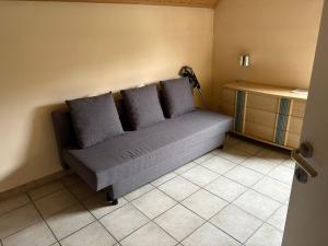 a couch sitting in a corner of a room at Owla-Stay in Heusden - Zolder