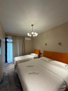a hotel room with two beds and a chandelier at Our House in Kobuleti