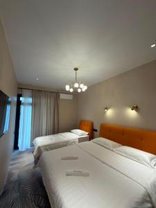 a hotel room with two beds and a chandelier at Our House in Kobuleti