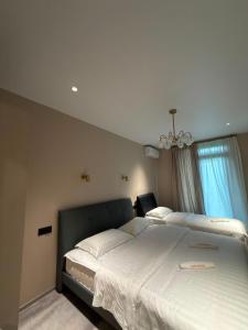 a bedroom with a large white bed with a chandelier at Our House in Kobuleti