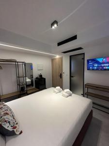 a bedroom with a large white bed and a flat screen tv at Perdika Ionion Villas in Perdika