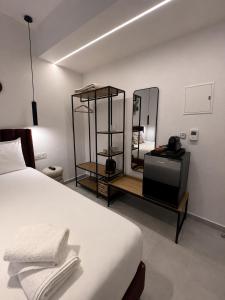 a bedroom with a white bed and a mirror at Perdika Ionion Villas in Perdika