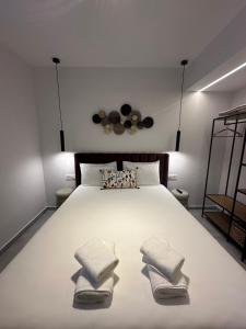 a bedroom with a large white bed with two pillows at Perdika Ionion Villas in Perdika