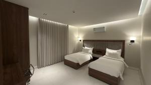 a hotel room with two beds and a window at شاليهات واجهة الشفا in Taif