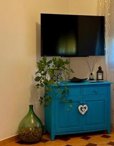 a blue cabinet with a tv on top of it at La Zia Acida Apartment in Ca Tiepolo