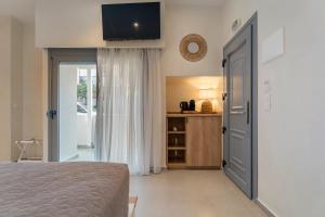 a bedroom with a bed and a tv on the wall at IOSIF hideaway in Neos Marmaras