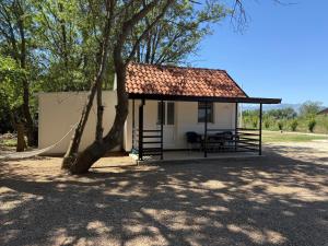 a small white building with a roof next to a tree at Kucice MMM in Donji Štoj