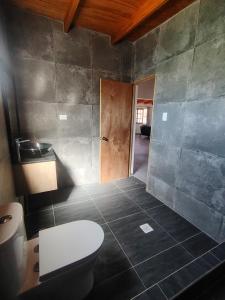 a bathroom with a toilet and a door in it at Casa Atitur in San Pedro de Atacama