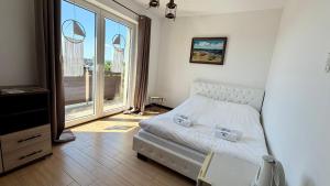 a bedroom with a bed and a large window at Angelika in Swarzewo