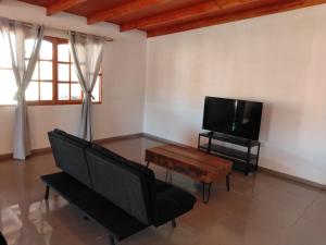 a living room with a couch and a flat screen tv at Casa Atitur in San Pedro de Atacama
