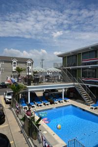 a large swimming pool in front of a hotel at Grecian Garden Motel in North Wildwood