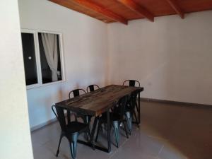 a wooden table and chairs in a room at Casa Atitur in San Pedro de Atacama +2 photos