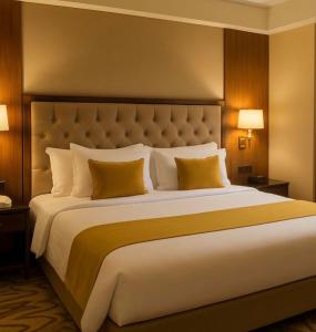 a bedroom with a large bed with yellow pillows at Peralam Rooms in Peralam Junction