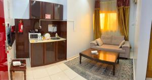 a living room with a couch and a coffee table at Al Samia economy apartment in Baljurashi