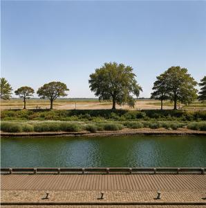 a bridge over a pond with trees in the background at Appartement Collection Sea View in Saint-Valéry-sur-Somme
